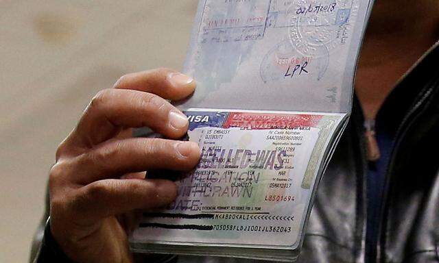 FILE PHOTO: A member of the Al Murisi family, Yemeni nationals who were denied entry into the U.S. last week because of the recent travel ban, show the cancelled visa in their passport at Washington Dulles International Airport in Chantilly