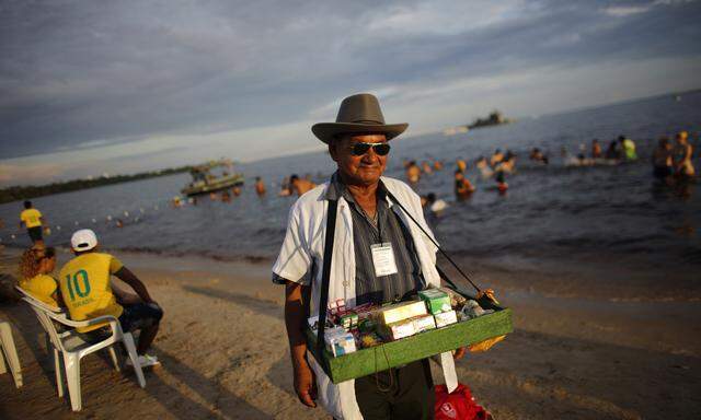 A street vendor strolls in a beach in Manaus