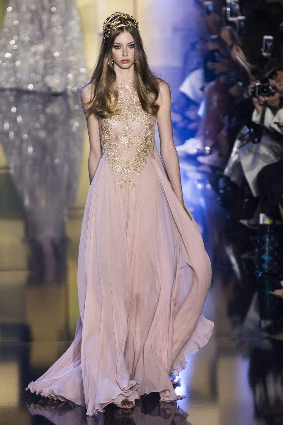 Der libanesische Designer Elie Saab betitelete seine aktuelle Kollektion "Shades of Gold". Die Symbolik des Luxus und Reichtums findet sich in seiner gewohnt extrem femininen Mode beispielsweise durch opulente Stickereien wieder.