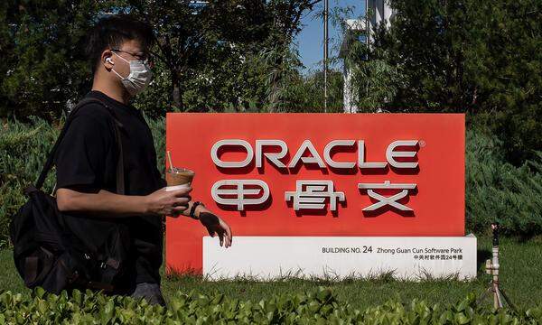 Ein Mann passiert das Firmenschild des Oracle-Office in Peking.
