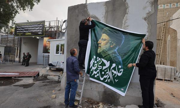 Vor der iranischen Botschaft in Bagdad wird ein Porträt des verstorbenen Ebrahim Raisi aufgehängt. Aber nicht alle Iraner trauern.