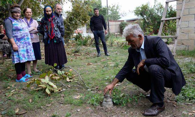 Bewohner der Stadt Beylagan in Aserbaidschan betrachten Reste eines mutmaßlich armenischen Geschosses.