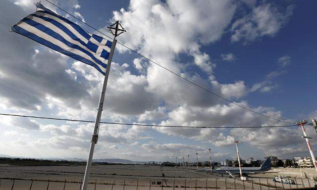 A Greek flag flutters in front of the old Hellenikon airport at Hellenikon suburb, south of Athens