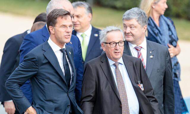 Jean-Claude Juncker (rechts) beim Nato-Gipfel mit dem niederländischen Ministerpräsidenten, Mark Rutte. Juncker musste am Donnerstag gestützt werden, am Vorabend war er auf einen Rollstuhl angewiesen.