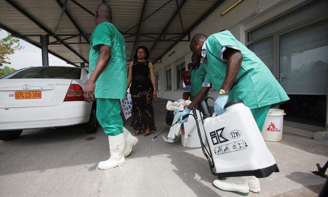 Mitarbeiter eines Krankenhauses in Kinshasa desinfizieren sich gegenseitig