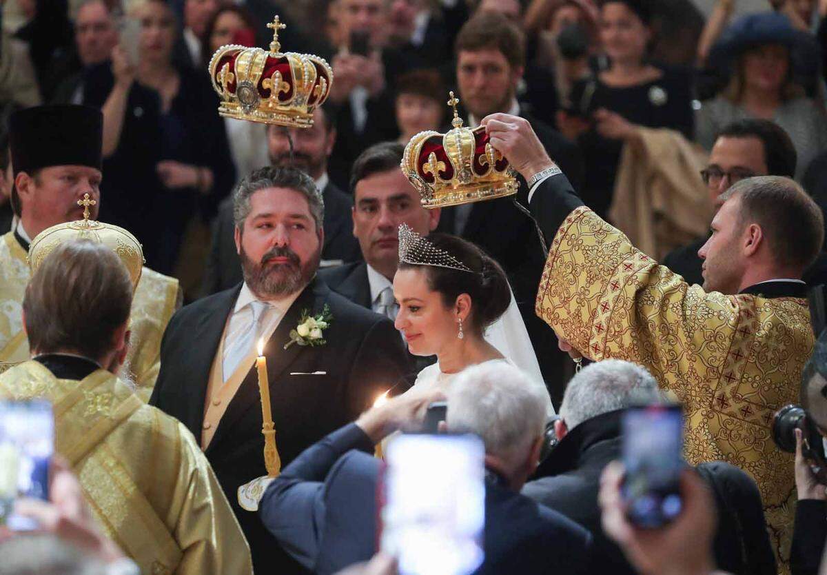 Braut und Bräutigam traten mit je einer Kerze in der Hand vor die in Gold gekleideten orthodoxen Priester. Nach orthodoxem Brauch wurden Braut und Bräutigam zwei Kronen über den Kopf gehalten.