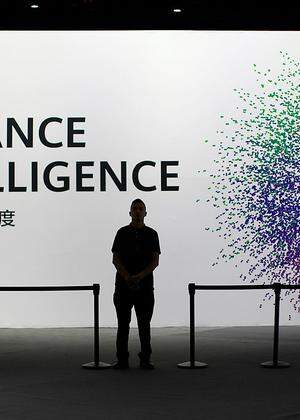 A security officer keeps watch in front of an AI (Artificial Intelligence) sign at the annual Huawei Connect event in Shanghai