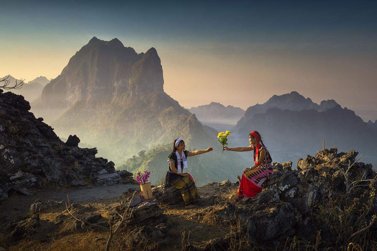 "Die Menschen des Kayin-Stammes leben an der Grenze zwischen Thailand und Myanmar. Als ich oben auf dem Berg ankam, entdeckte ich diese beiden Kayin-Damen, die miteinander plauderten und lachten. Mit einem so schönen Hintergrund konnte ich nicht anders, als diesen magischen Moment festzuhalten." - Fotograf Naing Tun Win Bagan aus Myanmar.