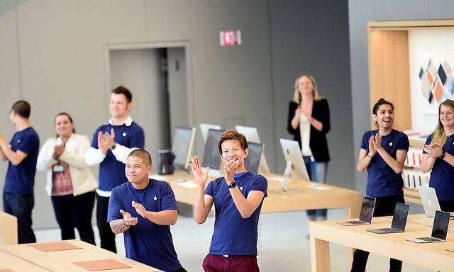 Apple employees applaud during a media preview for the company's new retail store in San Francisco