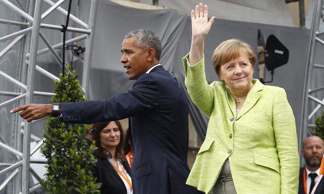 German Chancellor Merkel and former U.S. President Obama wave at the end of a discussion at the German Protestant Kirchentag in front of the Brandenburg Gate in Berlin