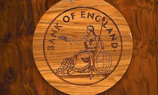 A wooden carving of the Bank of England logo is seen on a desk during a news conference at the Bank of England in London