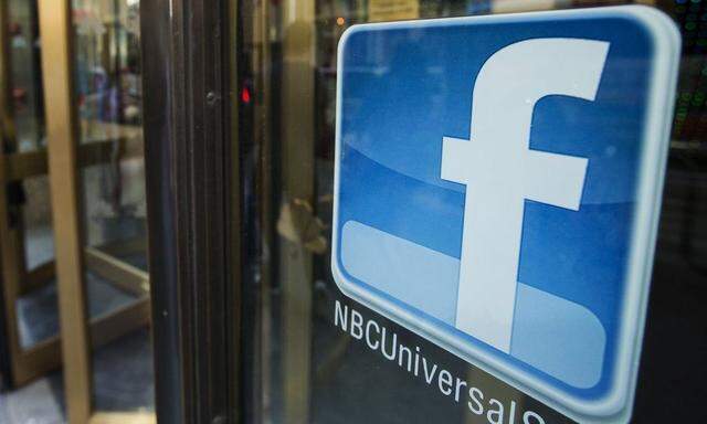 A Facebook logo is attached to the windows of the NBC store inside of Rockefeller Center in New York