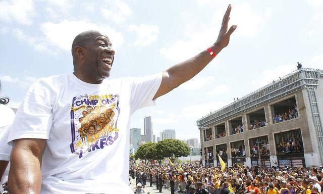 Magic Johnson waves to fans as the Los Angeles Lakers celebrate their NBA championship with a parade