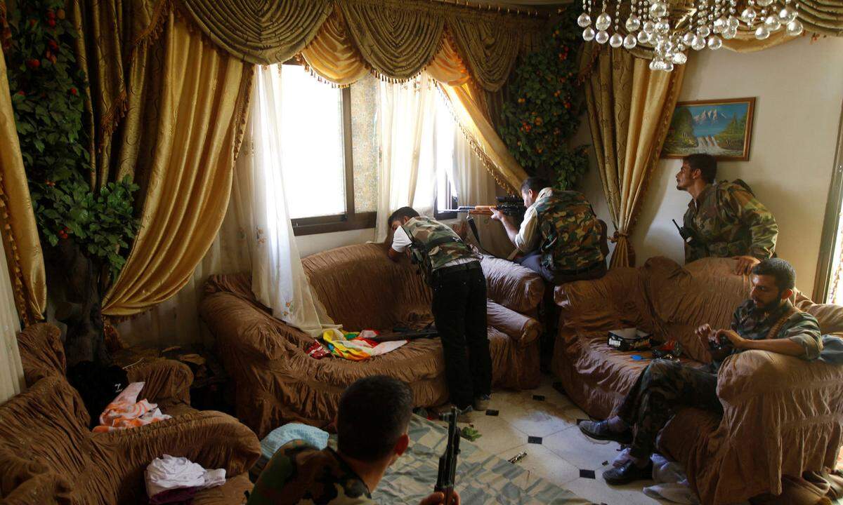 14. August 2012. Ein Kämpfer der Freien Syrischen Armee feuerte sein Gewehr aus dem Fenster eines Hauses in Aleppo ab.