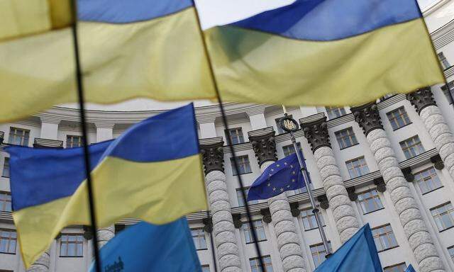 Ukrainian national flags, flags of Ukrainian trade unions and EU flag are seen during  a mass rally in front of the Ukrainian cabinet of ministers building in Kiev