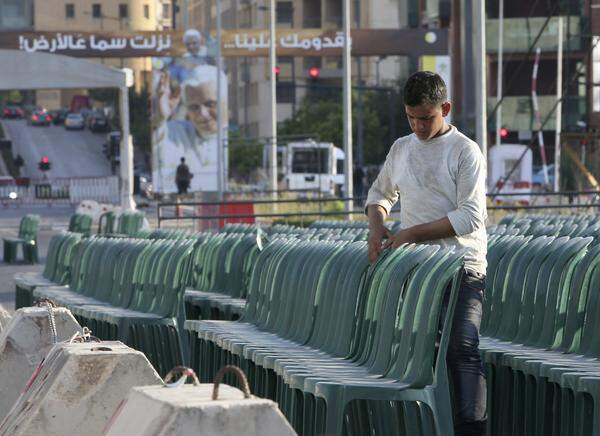 Ein Arbeiter richtet noch die Sitzreihen in Beirut zurecht.