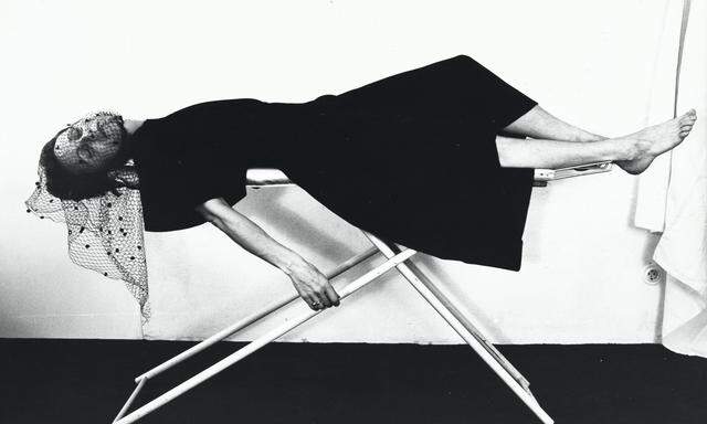 Erst bügelt sie noch die Wäsche. Dann ihren Trauerschleier. Dann bahrt sie selbst sich auf dem Brett auf: Das letzte von vier Fotos in „Bügeltraum“ von Karin Mack, 1975. 