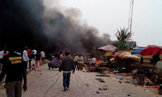 Smoke rises after a bomb blast at the market district in Jos