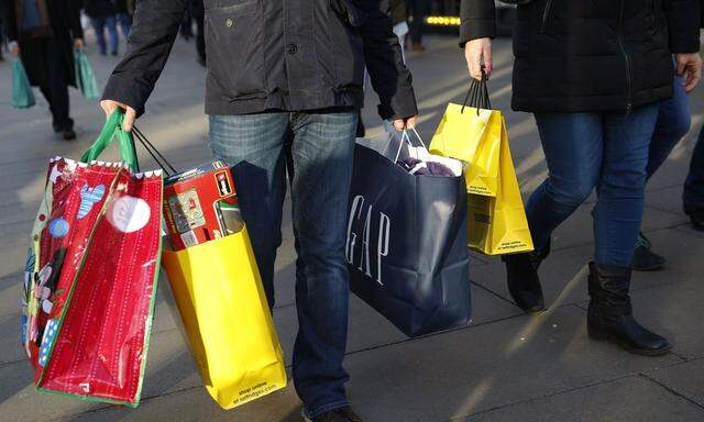 Shoppers carry bags along Oxford street during the final weekend of shopping before Christmas in London