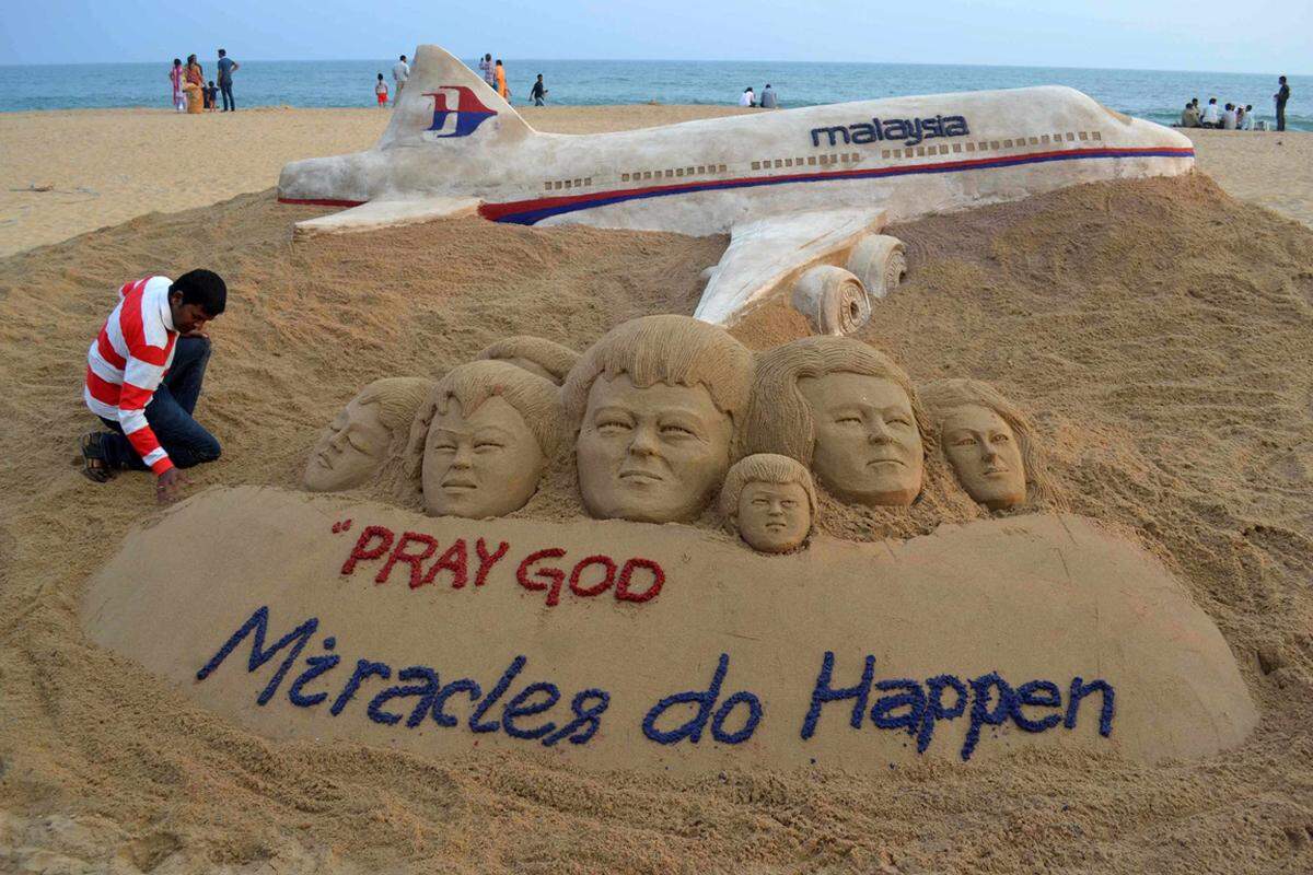 Sandkünstler Sudarshan Patnaik drückt sein Mitgefühl mit den Angehörigen aus. "Wunder passieren" schreibt er in sein Sandkunstwerk am ostindischen Strand von Puri.