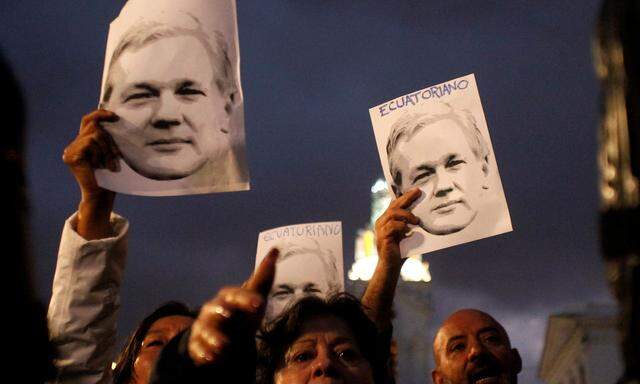 Unterstützer vorn Julian Assange halten Plakate mit seinem Konterfei. 