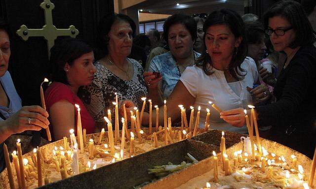 Jordanian Christians light candles during a mass at the Syriac Orthodox Church in Amman