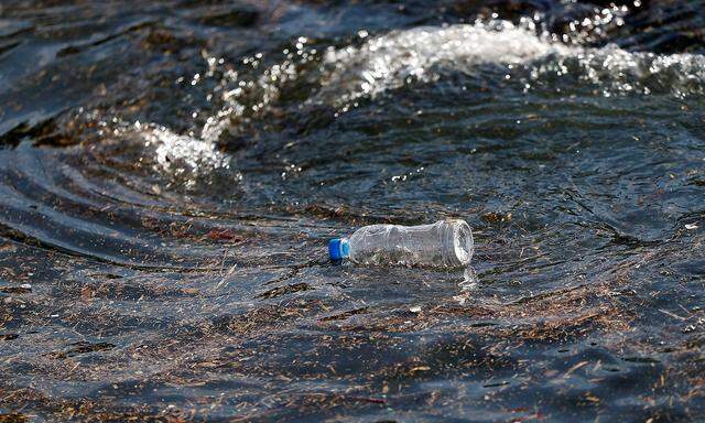 A plastic bottle drifts on the waves of the sea at a fishing port in Isumi