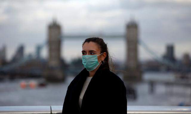 Woman wearing a protective face mask is seen on London Bridge in London