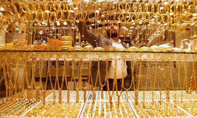 An Iraqi goldsmith arranges gold wristbands at his shop in Baghdad