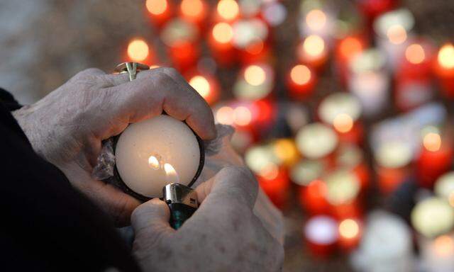 A local resident lights a candle during a remembrance ceremony for the victims of Tuesday´s shooting attack in Uhersky Brod
