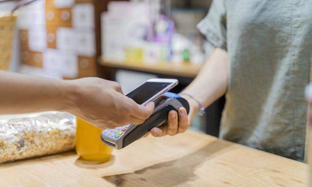 Customer paying cashless with smartphone in a shop model released Symbolfoto property released PUBLI
