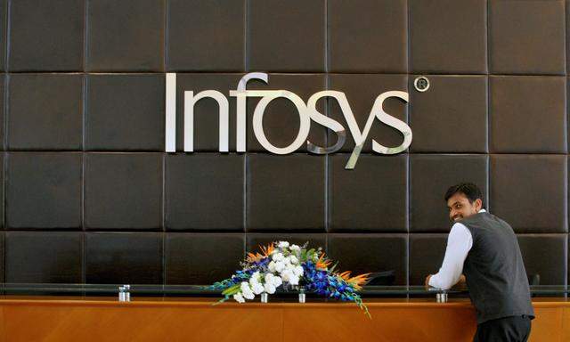 An employee of Infosys stands at the front desk of its headquarters in Bengaluru