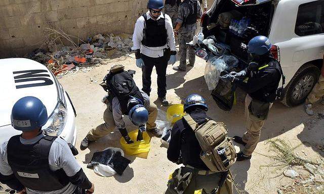 File photo of U.N. chemical weapons experts preparing before collecting samples from one of the sites of an alleged chemical weapons attack in Zamalka