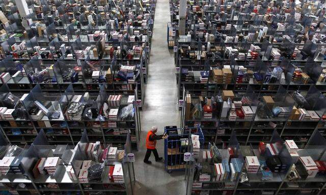 Worker collects items to pack into boxes at Amazon's logistics centre in Graben