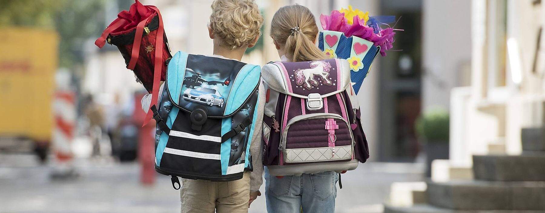 Zwei Kinder mit Schultuete auf Schulweg, von hinten (model-released) *** Two children with school bag on their way to s