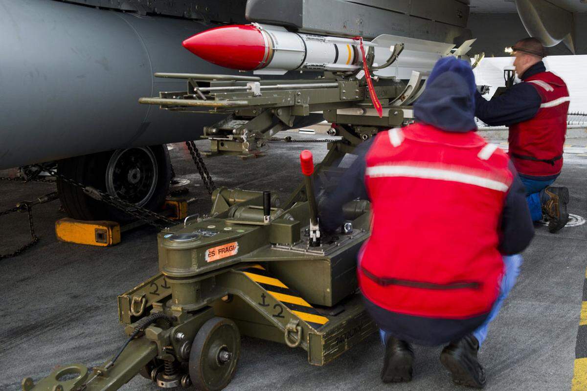 Ein französischer Kampfjet wird auf dem Flugzeugträger "Charles de Gaulle" für seinen Einsatz vorbereitet.