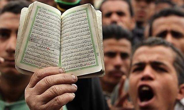 Woman holds Koran during a protest against the Egyptian military council at Tahrir square in Cairo