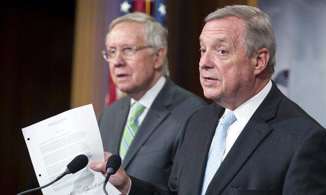 Senator Dick Durbin (D-IL)(R) holds a copy of the letter Senate Republicans sent to Iran as he and Senate Minority Leader Harry Reid (D-NV) speak after a vote failed to advance debate on a nuclear agreement with Iran, in Washington