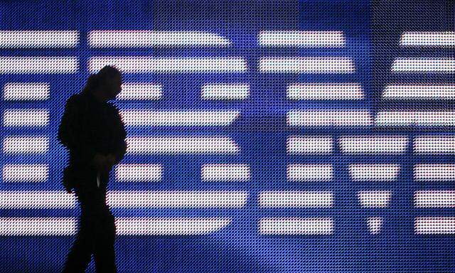 A worker is silhouetted in front of a huge screen with the IBM logo ahead of the CeBIT fair inside a hall in Hanover