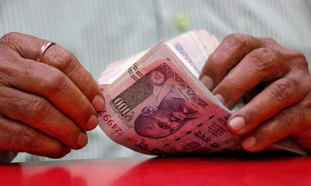 A man counts Indian currency notes inside a shop in Mumbai