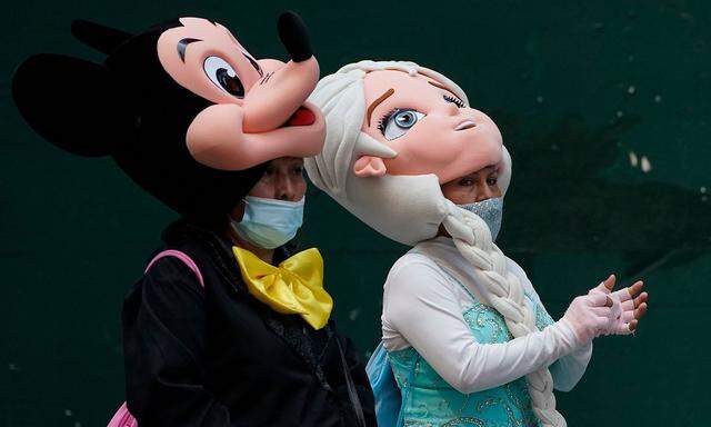 Masken-Parade auf dem New Yorker Times Square mit Mickey und Elsa. Die steigenden Fallzahl sorgen auch in den USA für Debatten.