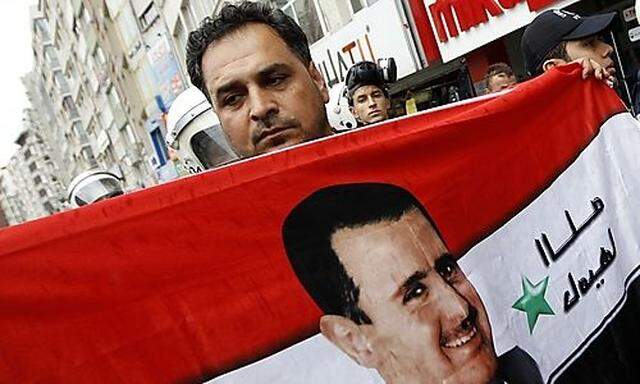 Ein Anhänger Präsident Bashir al-Assads mit dessen Konterfei