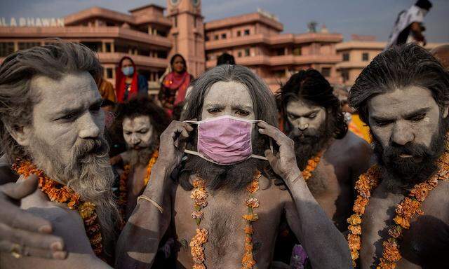 A Naga Sadhu, or Hindu holy man wears a mask before the procession for taking a dip in the Ganges river during Shahi Snan at 'Kumbh Mela', or the Pitcher Festival, amidst the spread of the coronavirus disease (COVID-19), in Haridwar