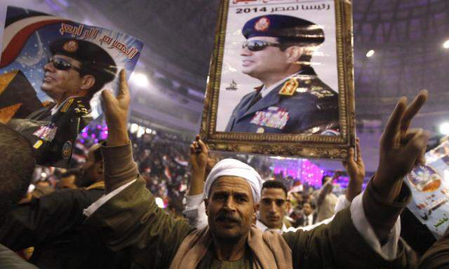 Supporters of Egypt´s army chief Sisi hold posters during festivities in Cairo