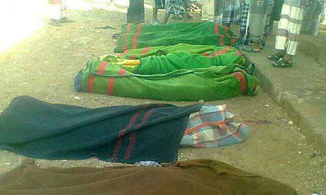 Dead soldiers are wrapped in blankets after gunmen opened fire at the military headquarters in Mayfaa