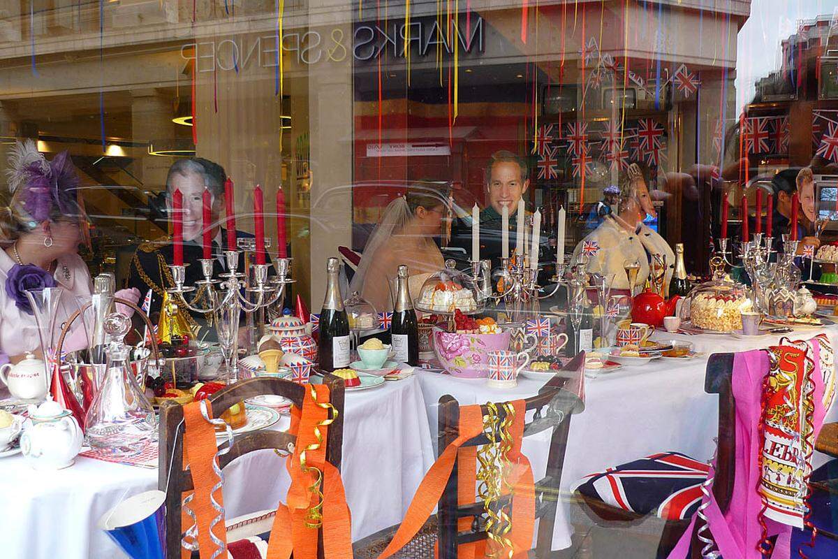 Der Hype um das Brautpaar treibt immer kuriosere Blüten: In einem Kaufhaus in der Oxford Street feiert eine maskierte royale Tischgesellschaft den ganzen Donnerstag Hochzeit.