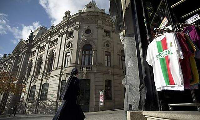 A nun passes a branch of the Bank of Portugal in central Porto, Portugal, Wednesday, Nov. 17, 2010. E