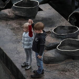 Children depict a Soviet monument to a friendship between Ukrainian and Russian nations after its demolition in central Kyiv