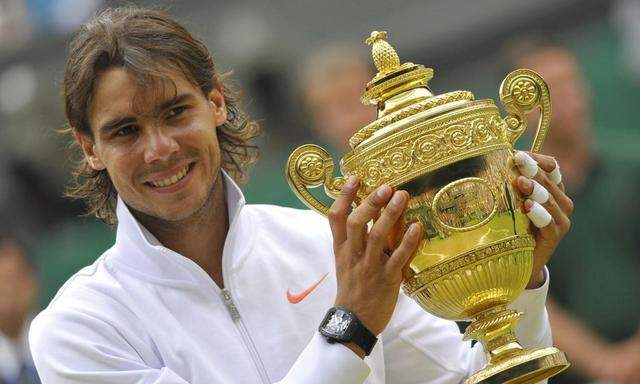 Spain's Rafael Nadal poses for a photograph with the winners trophy after defeating Tomas Berdych of the Czech Republic in the men's singles final at the 2010 Wimbledon tennis championships in London