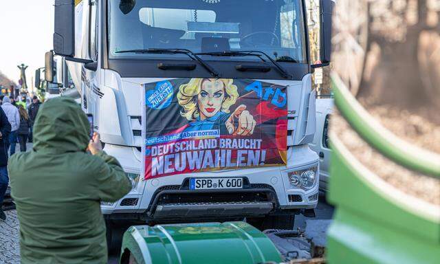 Ein Teilnehmer an den Bauernprotesten in Berlin tauchte mit einem AfD-Plakat auf. Eigentlich sollte es um einen Steuernachlass auf Diesel gehen.